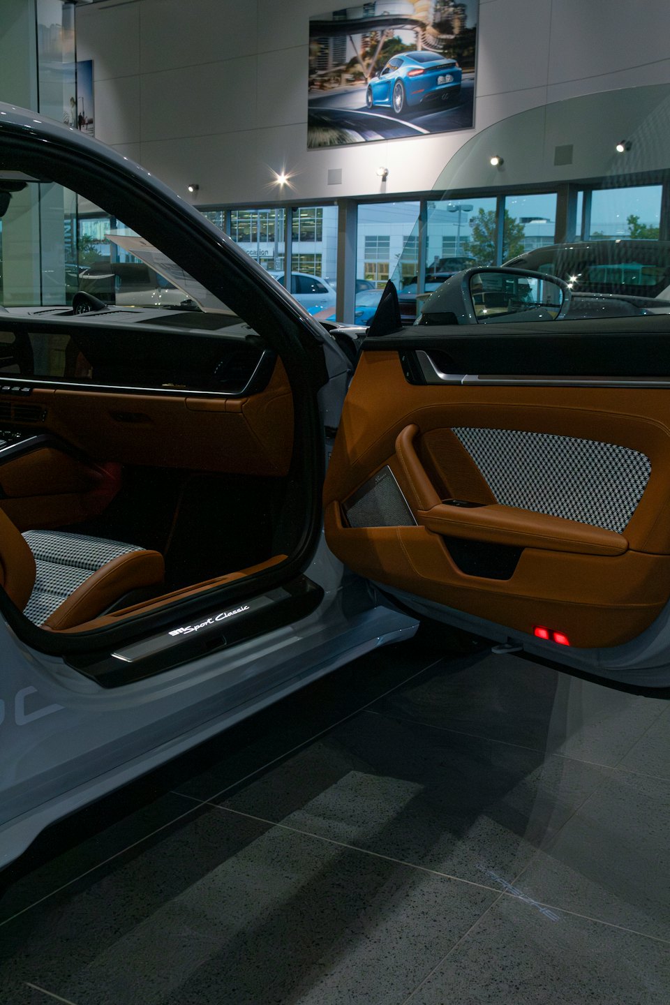 Open driver door revealing leather seats and a metal scuff plate.